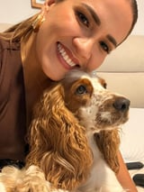 A woman with curly hair and a dog.