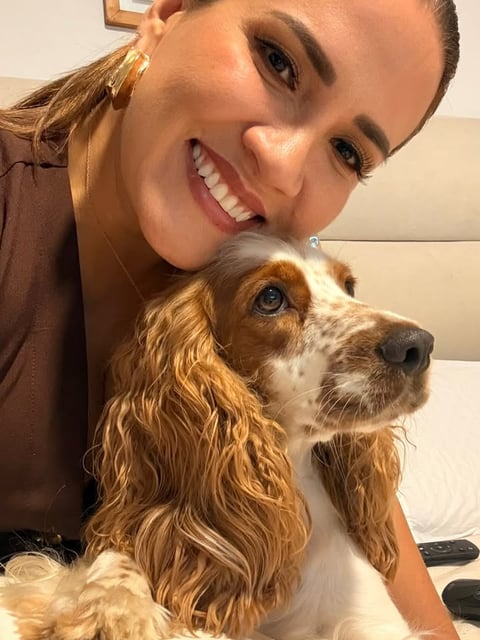 A woman with curly hair and a dog.