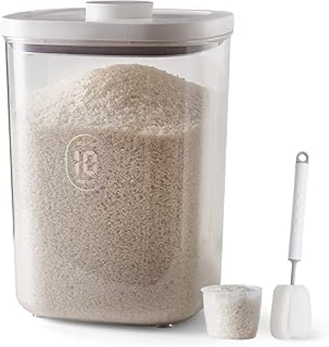 A container of rice with a spoon next to it.