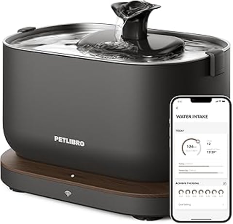 A black pet water fountain with a stainless steel tray and a smartphone app to monitor the water intake.