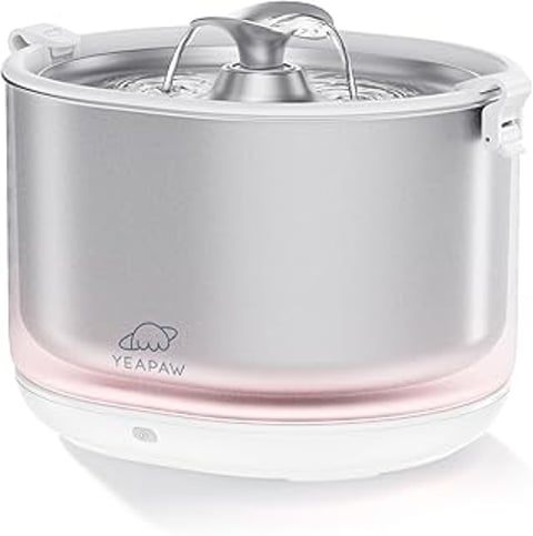 A cat water fountain is pink and silver.