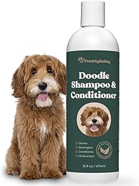 A brown dog with a pink tongue sits next to a bottle of Doodle Shampoo and Conditioner.